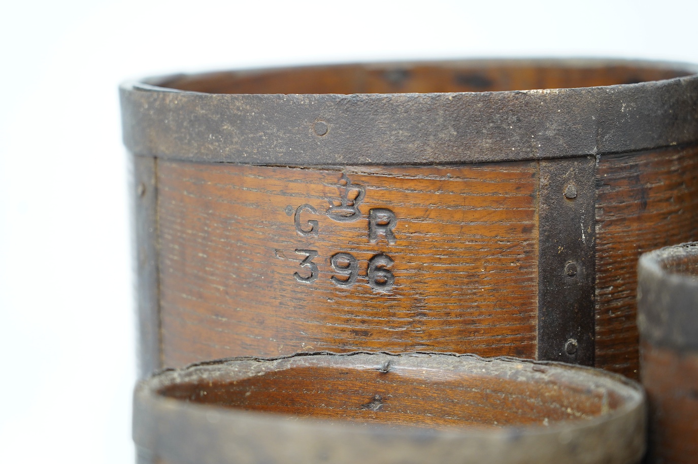 A matched set of five early 20th century iron bound bushel measures, one peck to half pint, together with a pressed card paper basket. Condition - fair to good